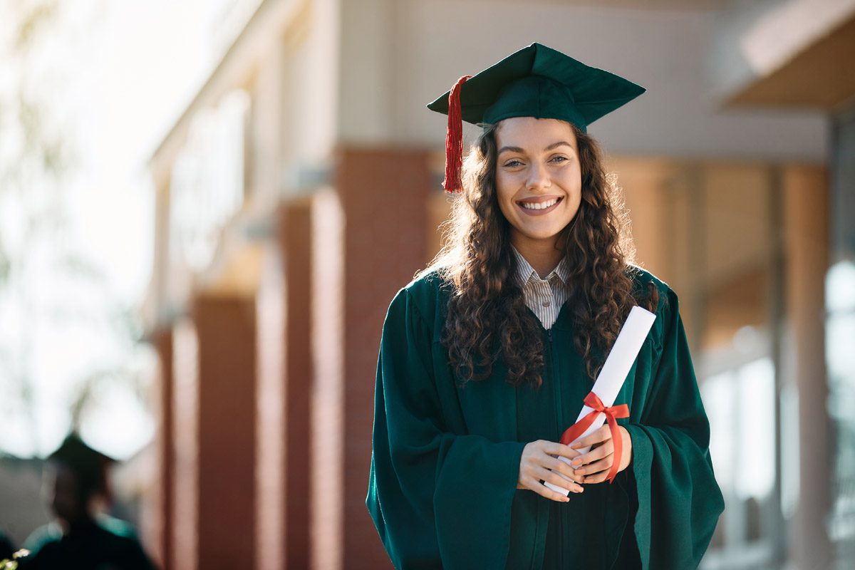 Happy Female Graduate Student With Diploma Looking At Camera.