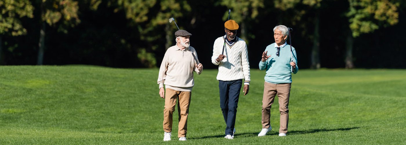 Interracial Senior Friends Walking With Golf Clubs On Field, Banner.
