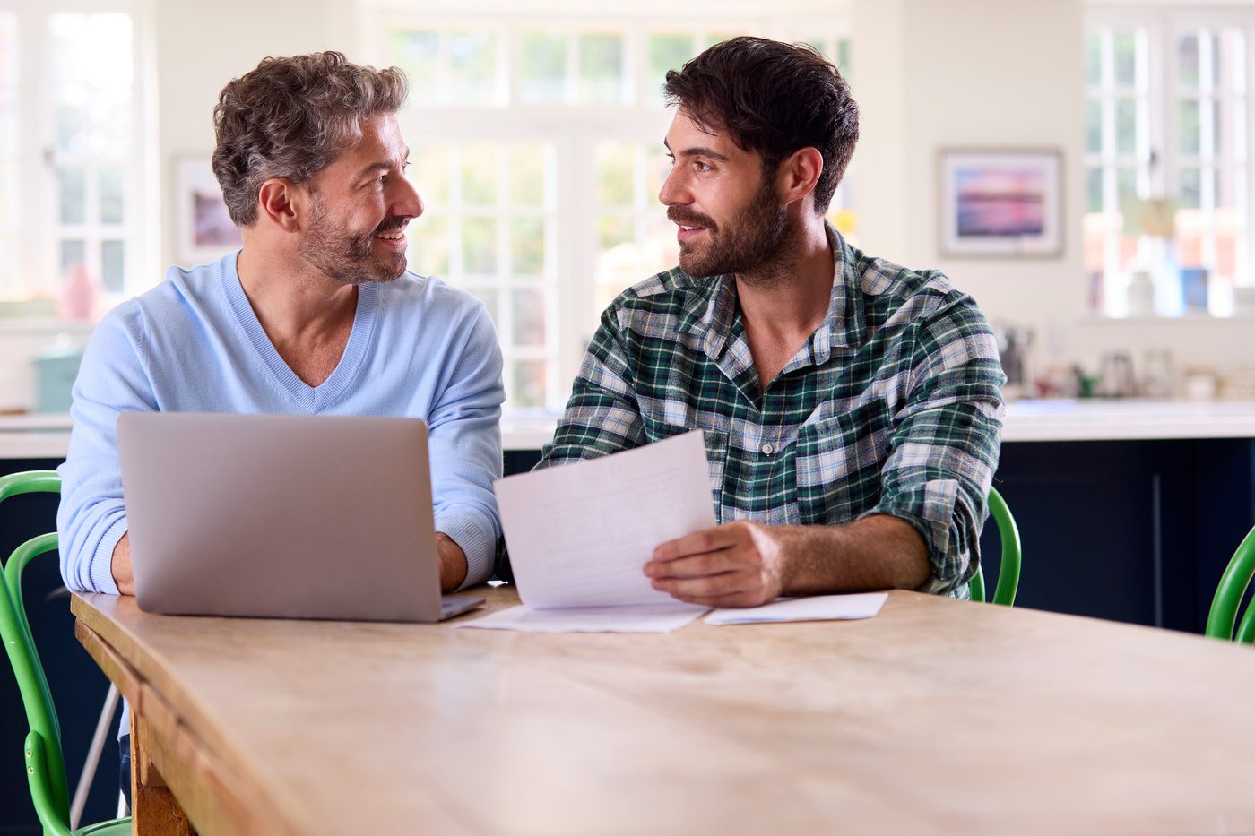 Same Sex Male Couple Using Laptop At Home To Check Domestic Finances